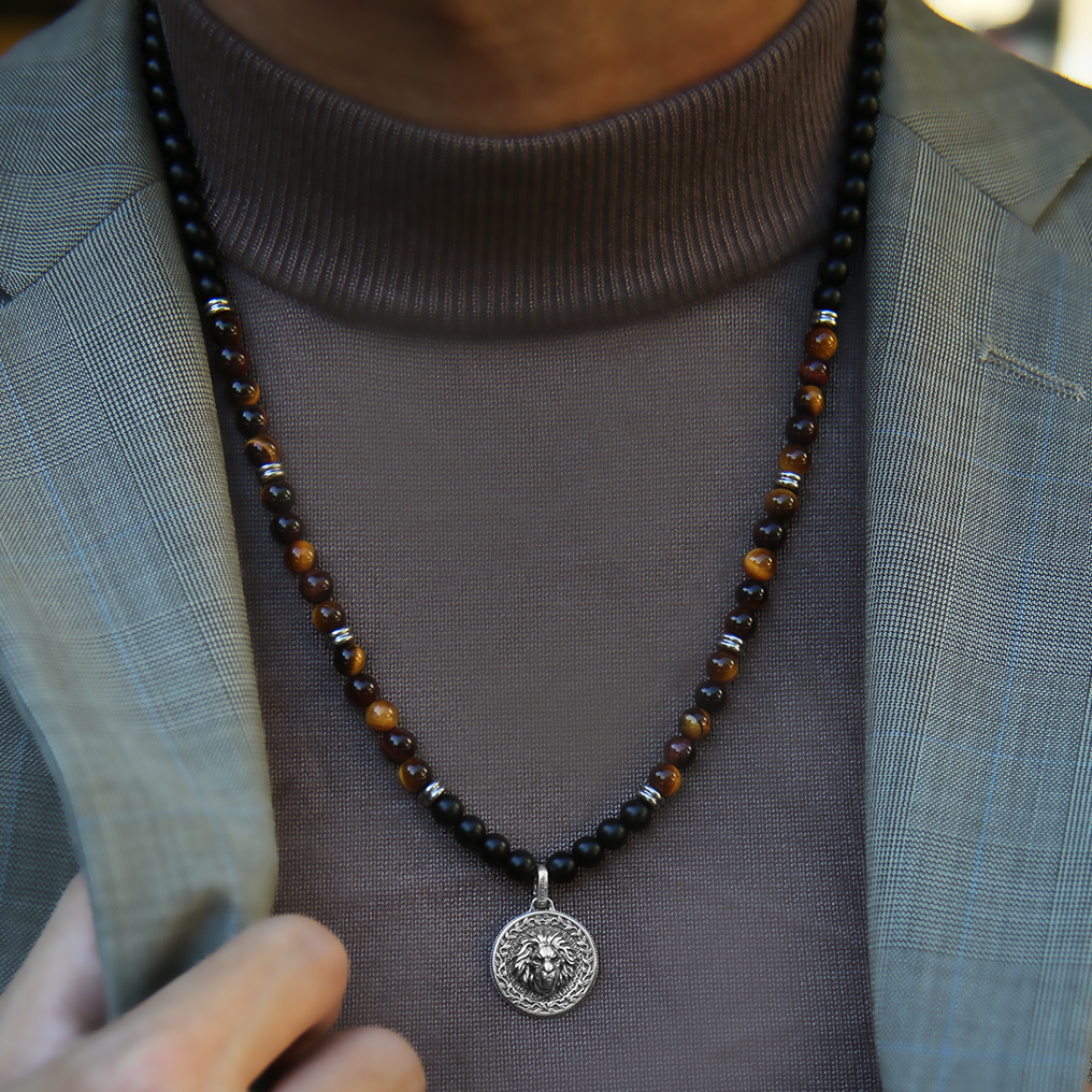 Red Tiger Eye beaded pendant necklace brings wealth and luck. A set of Obsidian crystals highlights the detail of the silver pendant. Mix red Tiger eye beads and Obsidian beads and bring in healing properties of protection and prosperity. Silver pendants for men in oxidization showcase masculinity.