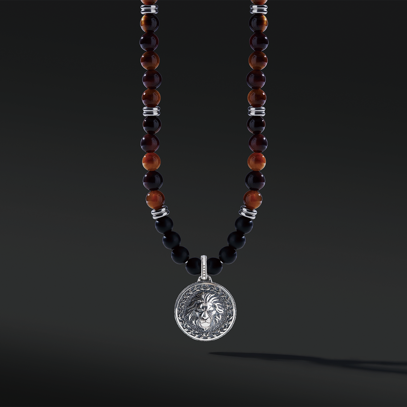 Red Tiger Eye beaded pendant necklace brings wealth and luck. A set of Obsidian crystals highlights the detail of the silver pendant. Mix red Tiger eye beads and Obsidian beads and bring in healing properties of protection and prosperity. Silver pendants for men in oxidization showcase masculinity.