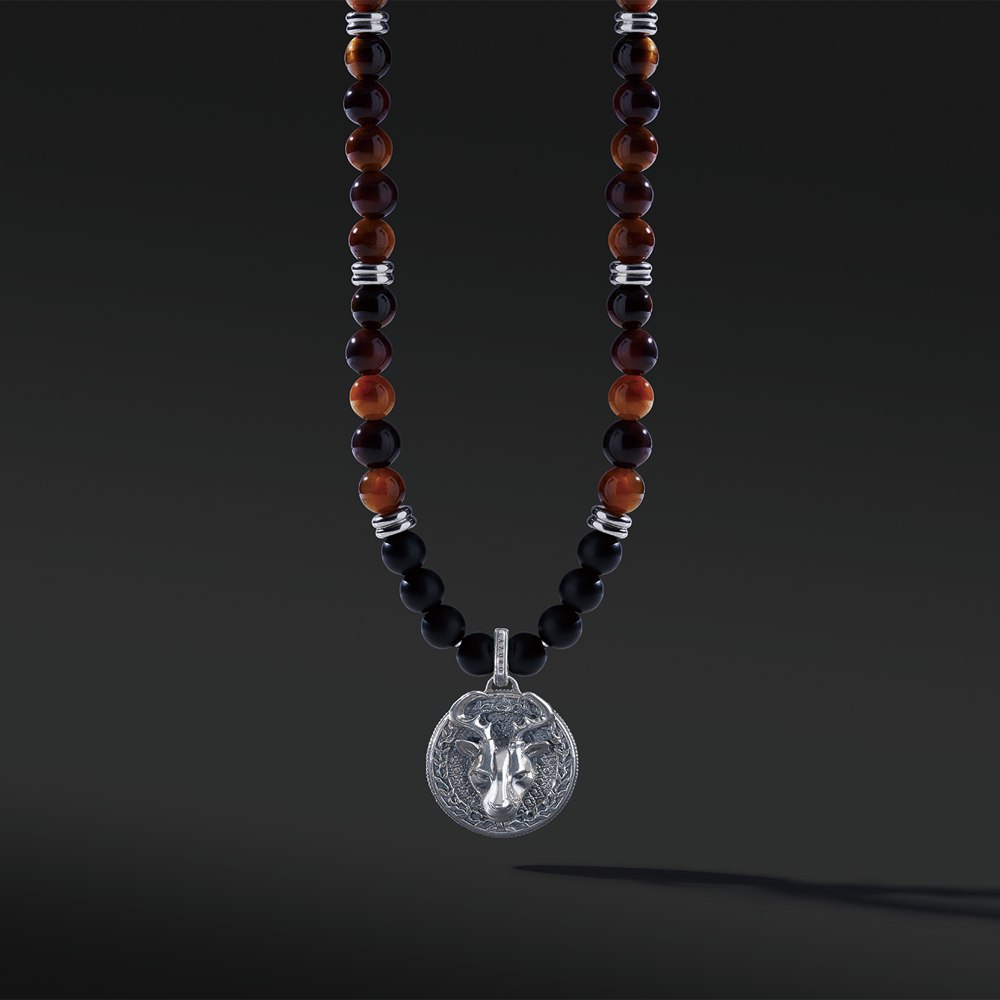 Red Tiger Eye beaded pendant necklace brings wealth and luck. A set of Obsidian crystals highlights the detail of the silver pendant. Mix red Tiger eye beads and Obsidian beads and bring in healing properties of protection and prosperity. Silver pendants for men in oxidization showcase masculinity.