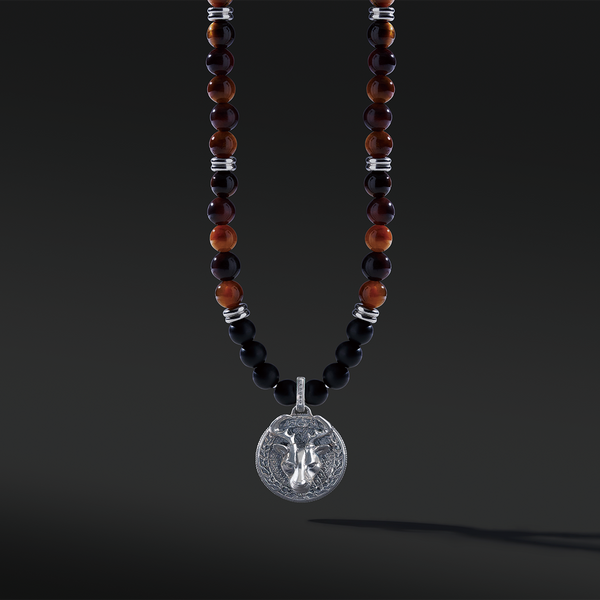 Red Tiger Eye beaded pendant necklace brings wealth and luck. A set of Obsidian crystals highlights the detail of the silver pendant. Mix red Tiger eye beads and Obsidian beads and bring in healing properties of protection and prosperity. Silver pendants for men in oxidization showcase masculinity.